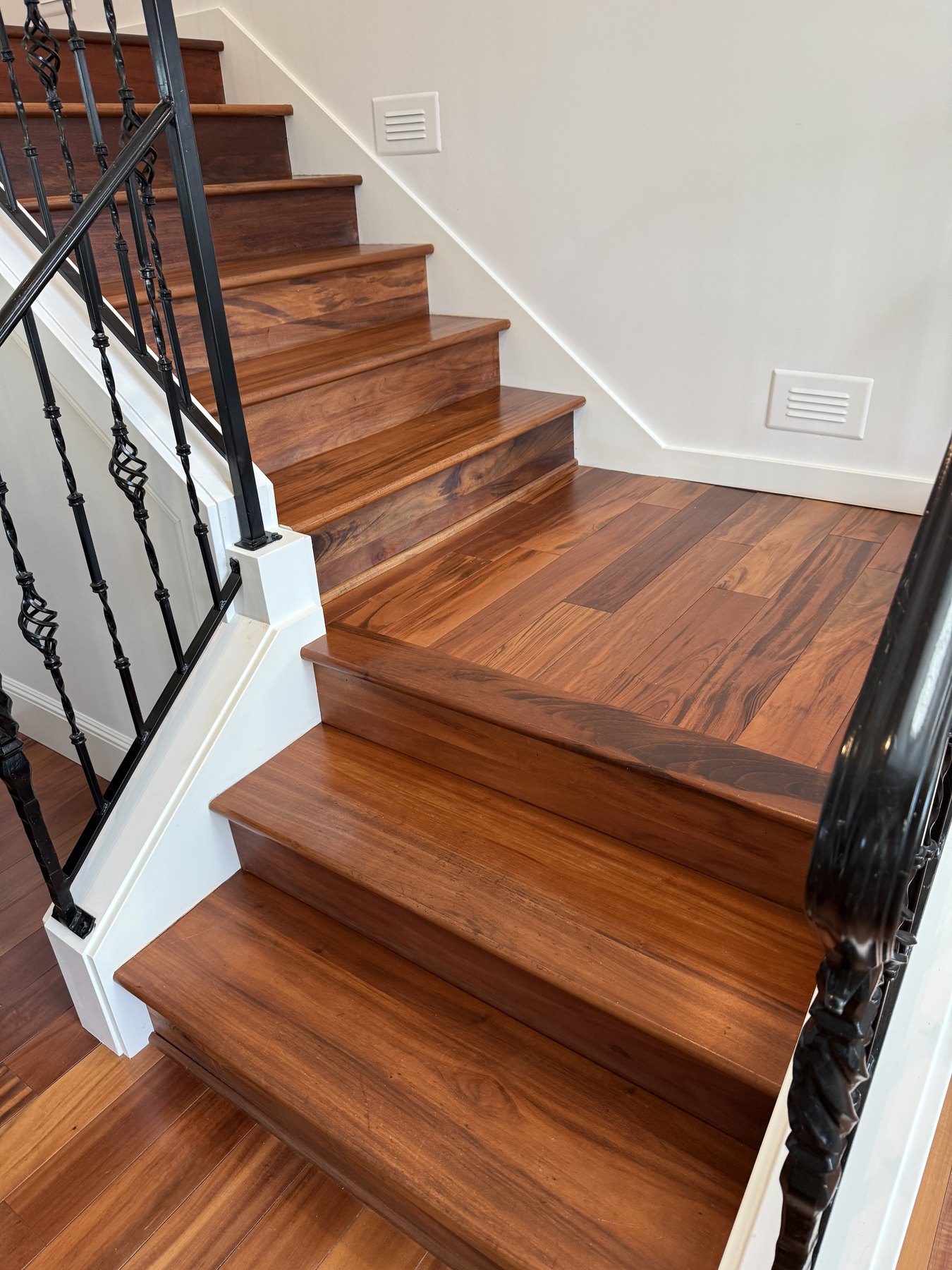 Detailed white trim, hardwood stairs and black ironwork in a finished residence